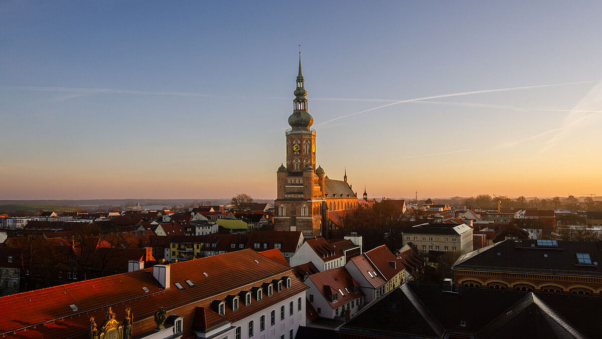Blick über das Unihauptgebäude auf den Dom St. Nikolai in Greifswald